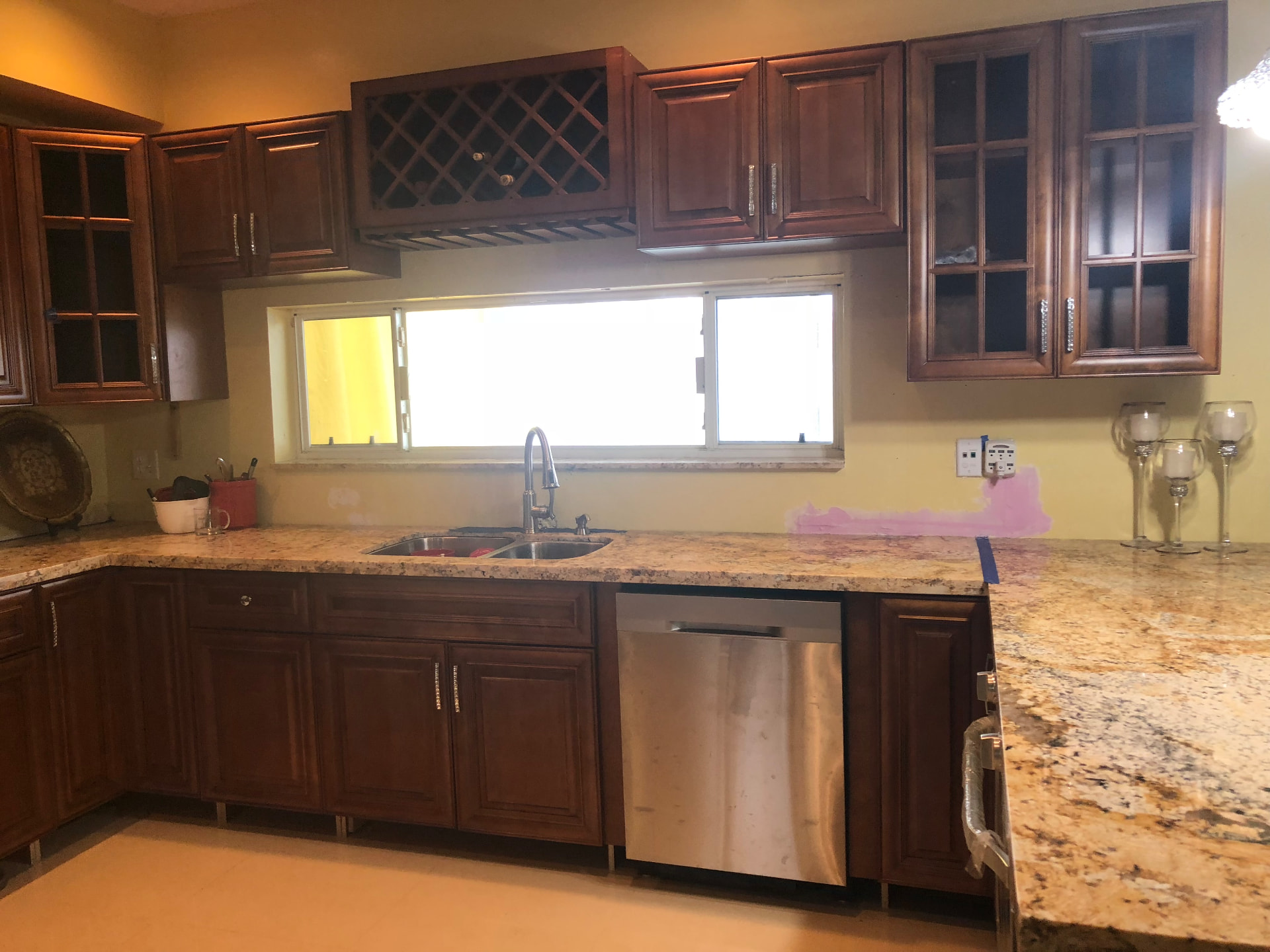 Completed kitchen sink run with granite counters, stainless dishwasher and pull-down faucet