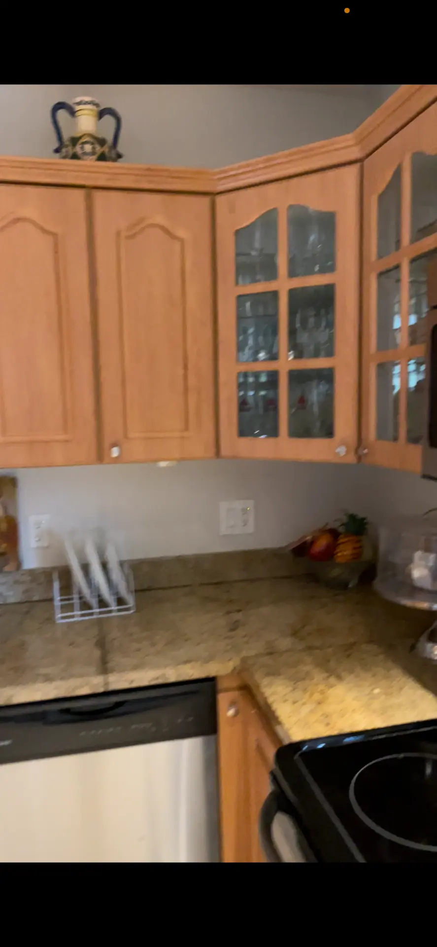 Existing corner upper cabinets with arched and glass-front doors before remodeling
