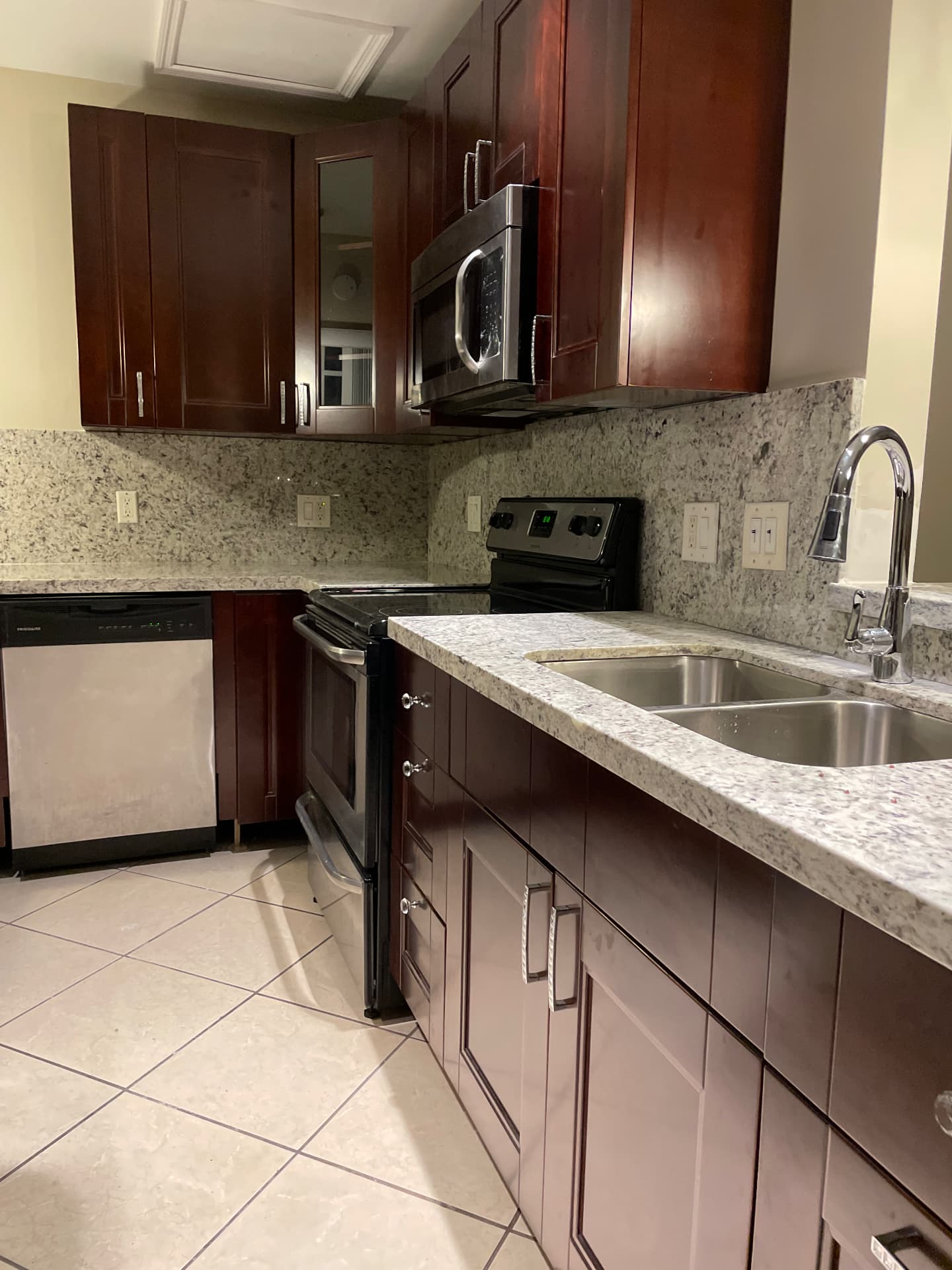 Completed kitchen run with granite counters, stainless range, microwave and double sink