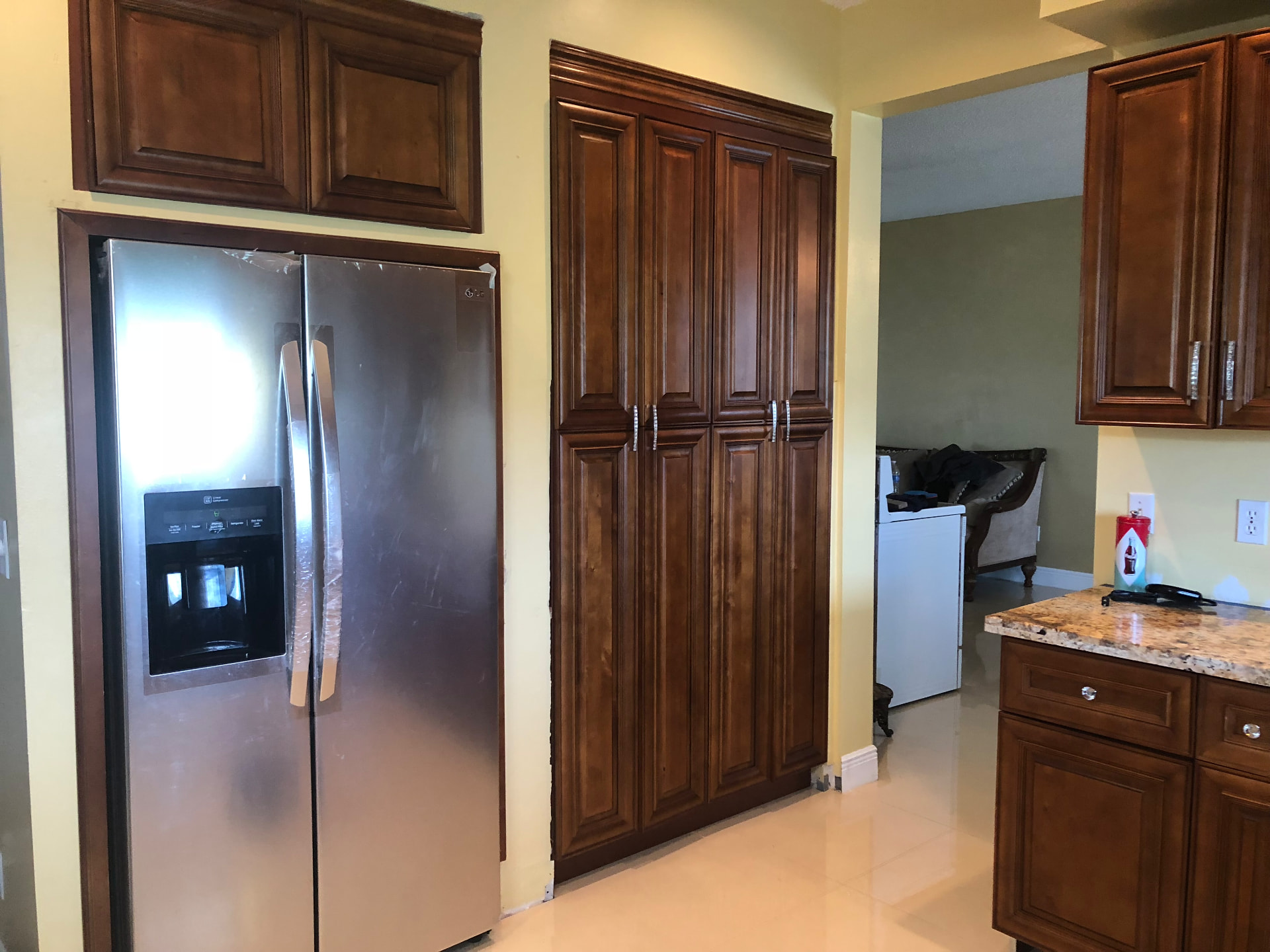 Completed refrigerator surround and pantry cabinetry with crown molding