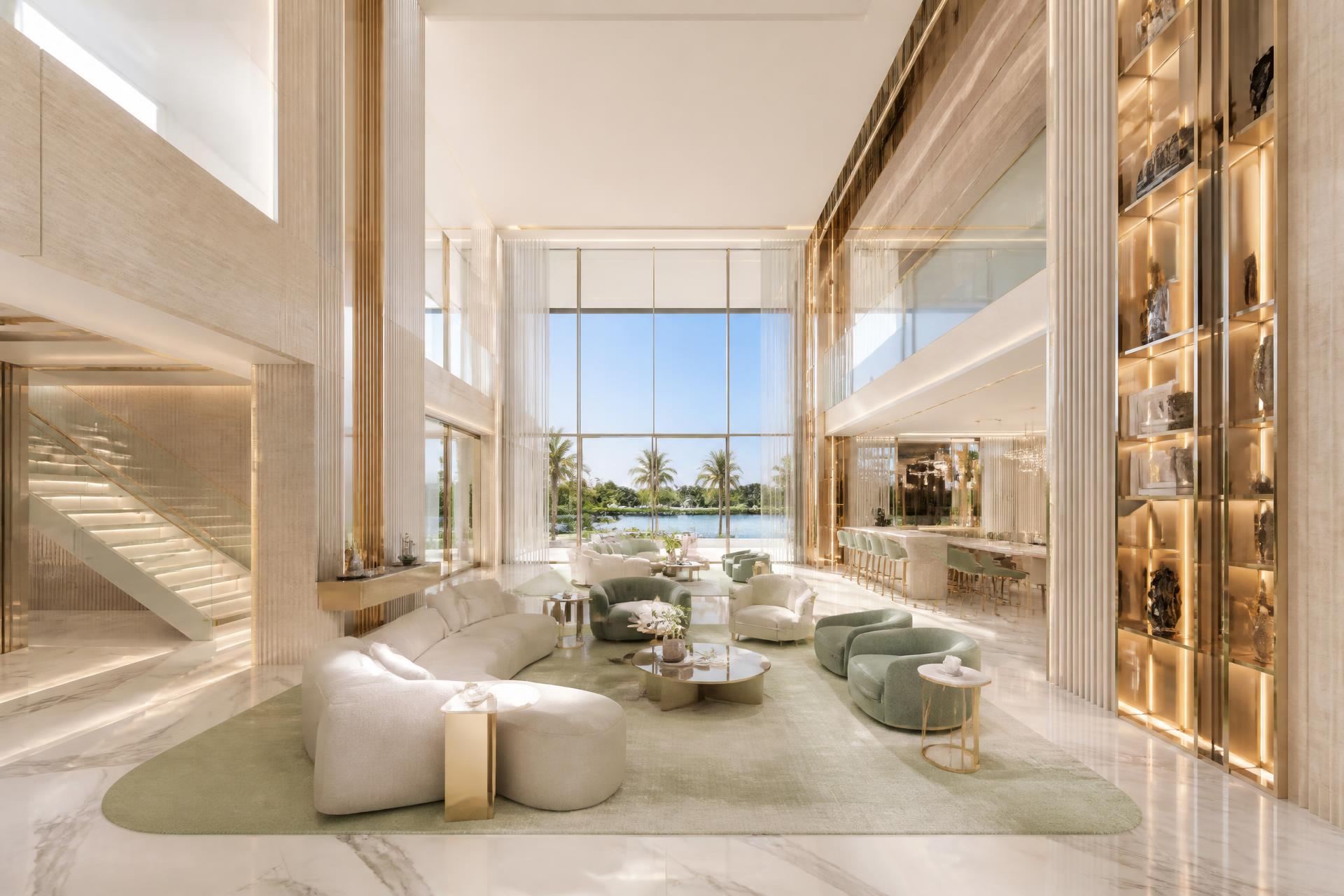 Double-height luxury Miami living space with marble floors, warm beige stone and champagne gold detailing